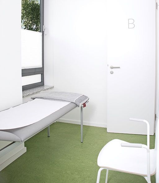 Patientenzimmer hell eingerichtet mit einem Patientenbett am Fenster und ein Stuhl für Gäste.