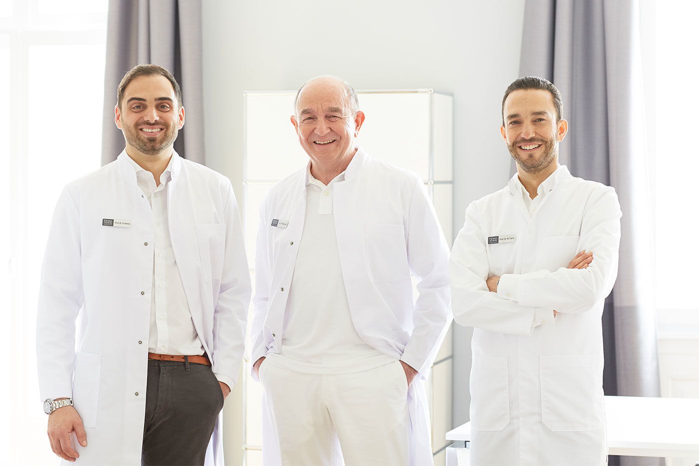 Von links nach rechts stehen Prof. Dr. med. Vincenzo Penna, Dr. med. Rolf Kleinen und Prof. Dr. med. Nestor Torio-Padron lächelnd im Beratungszimmer.