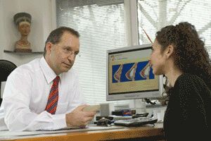 Im Büro von Hans-Jürgen Rabe klärt er einer anderen Patientin am Computer über eine Brustvergrößerung auf. Beide sind vertieft in das Gespräch.