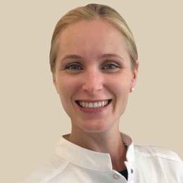 Headshot von Dr. med. Juliane Finke lächelnd. Aufgenommen vor einem hellen Hintergrund.