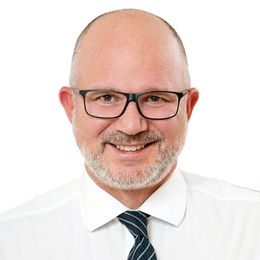 Headshot von Prof. Dr. Lars Steinsträßer lächelnd. Aufgenommen vor einem hellen Hintergrund.
