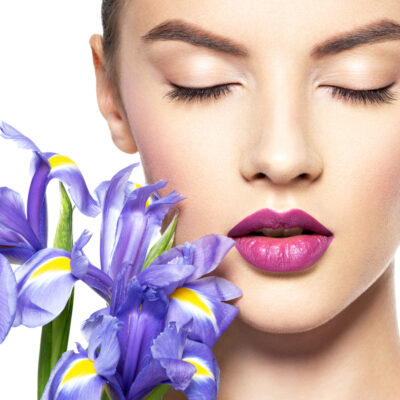 Schöne Frau mit geschlossenen Augen und Lilien ohne Bunny Lines nach Botox Behandlung.
