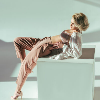 Frau mit flachem Bauch halb liegend nach einer Bauchdeckenstraffung mit Diastasis Recti.